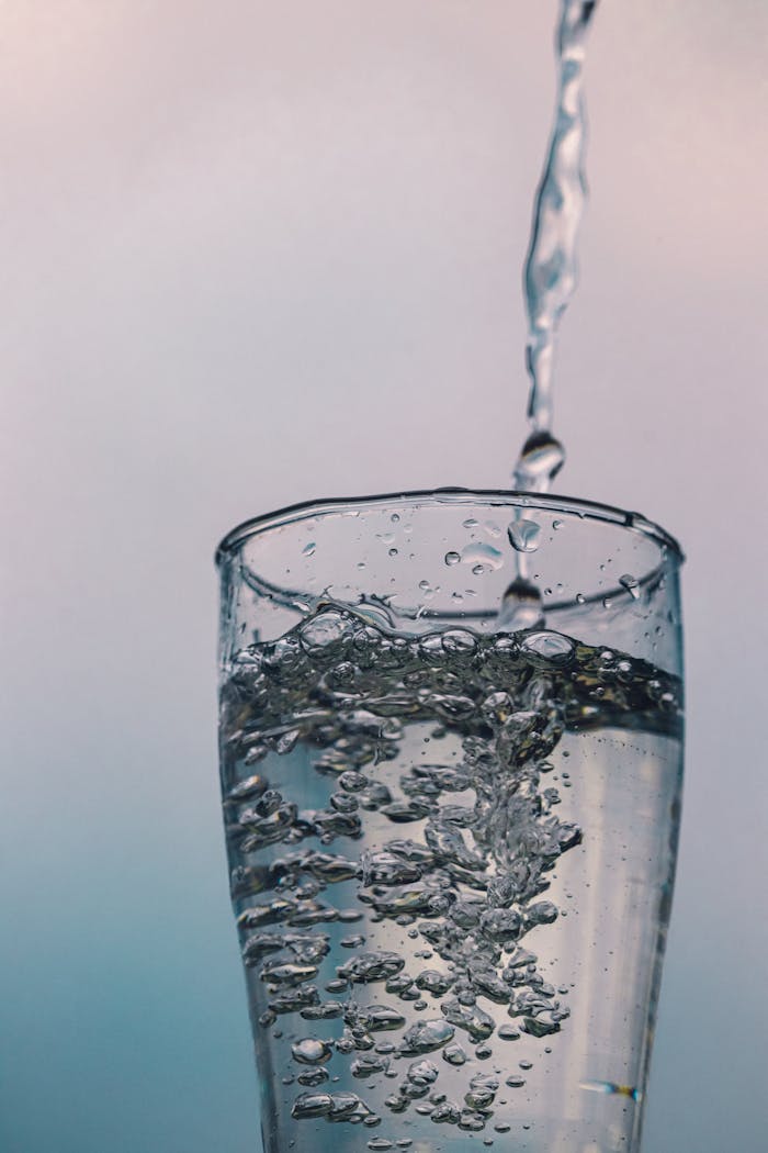 Close-up of a glass filled with sparkling water bubbles, depicting freshness and hydration.